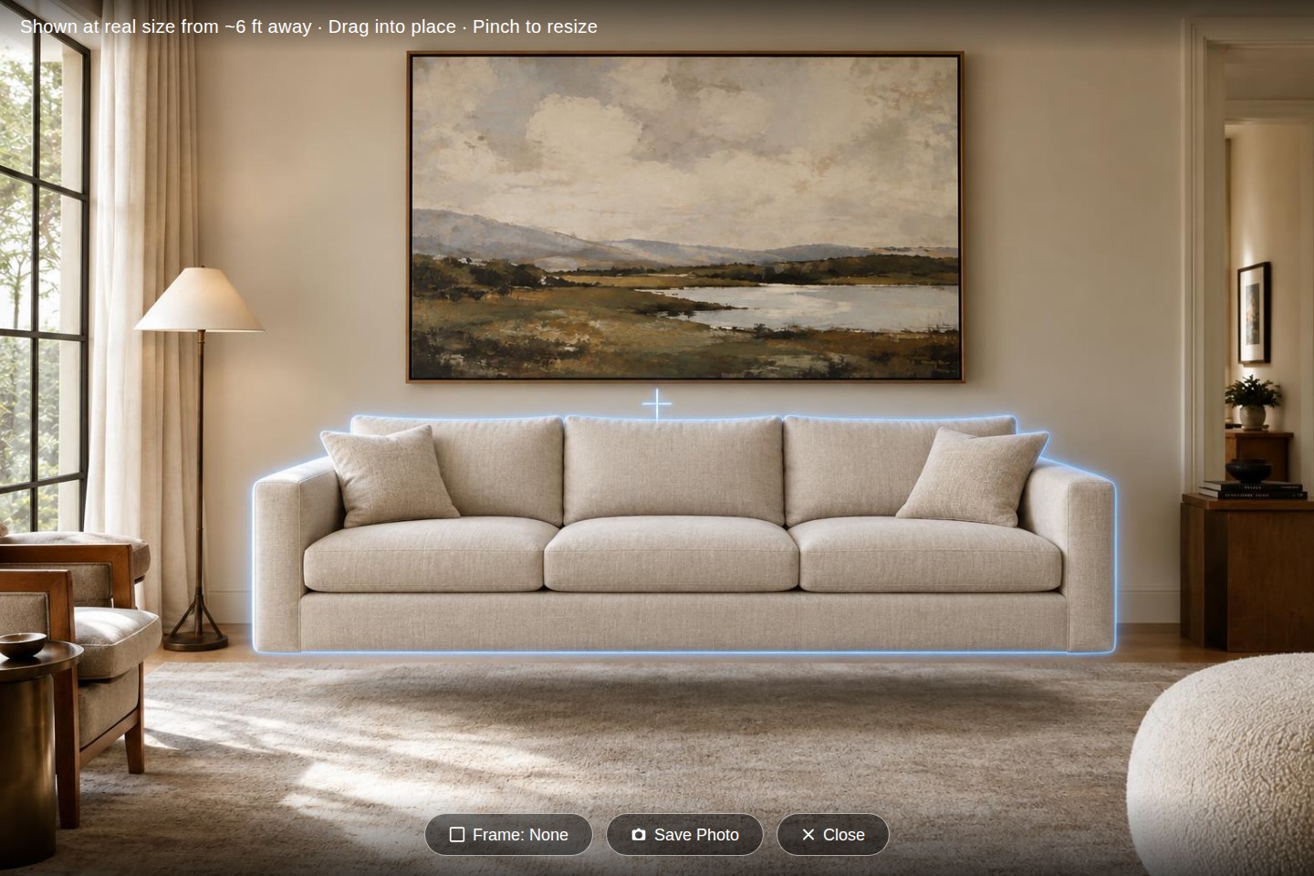 The view-through-your-phone AR tool: a sofa placed into a real room at true scale with frame and save-photo controls